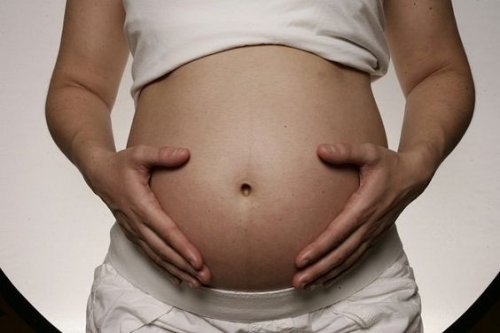 Moeder houdt zwangere buik vast