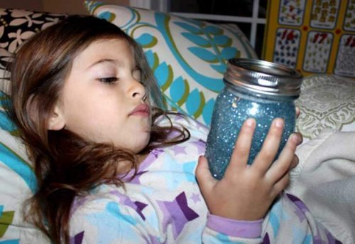 Meisje ontspant in bed met sensorische fles