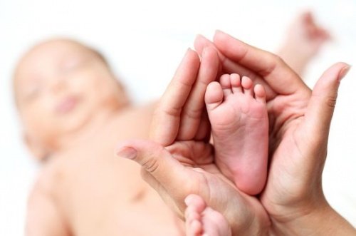 Mama houdt voeten van baby vast