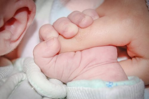De voordelen van borstvoeding: vingers grijpen hand