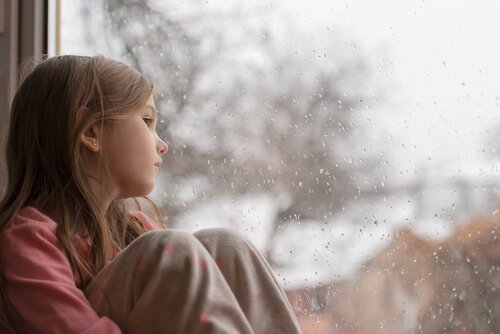 Verdrietig kind bij het raam