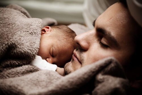 Baby in slaap op de borst van papa
