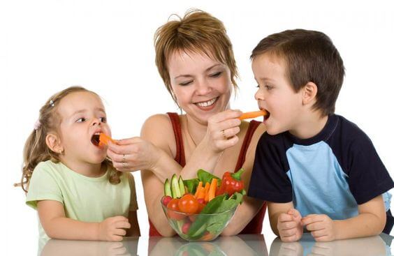 Moeder voert worteltjes aan haar kinderen