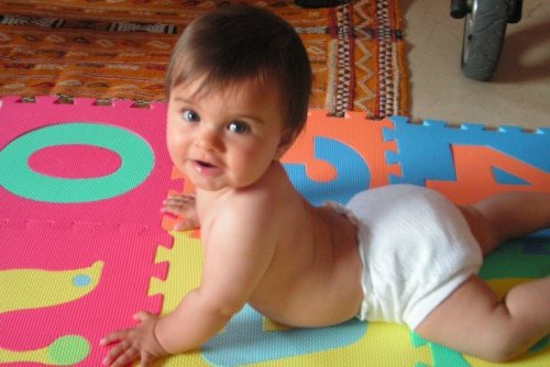 Baby in luier op speelmat