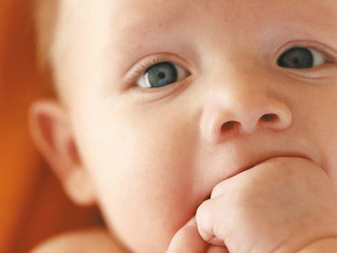 Een baby zuigt op zijn hand