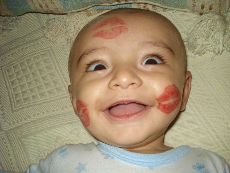 Baby met lippenstift-kusjes