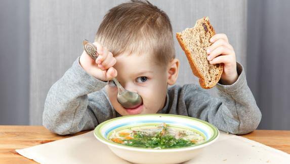 Jongen eet brood en soep