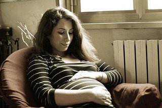 Vrouw met streepjes trui en zwangere buik