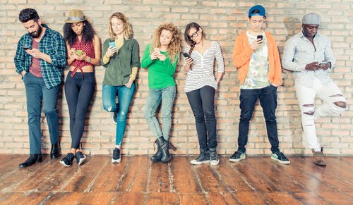 Groep tieners allemaal op hun mobiel bezig