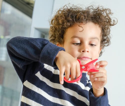 Jongetje knipt geconcentreerd iets door