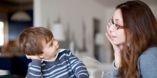 Moeder met bril praat met kind in gestreept shirt