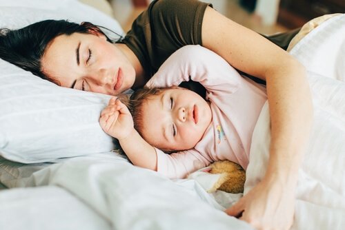 Moeder houdt kind vast tijdens het slapen