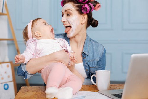 Moeder steekt tong uit baby lacht