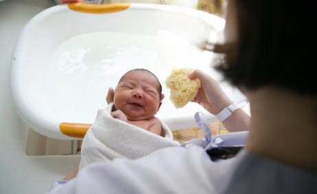 Moeder houdt baby in handdoek vast