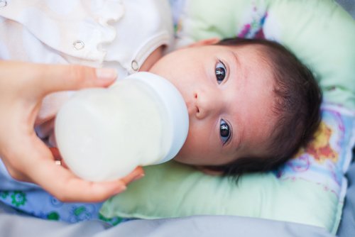 Afbouwen van de borstvoeding: baby met flesje