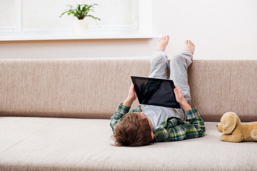 Jongen met ipad op de bank