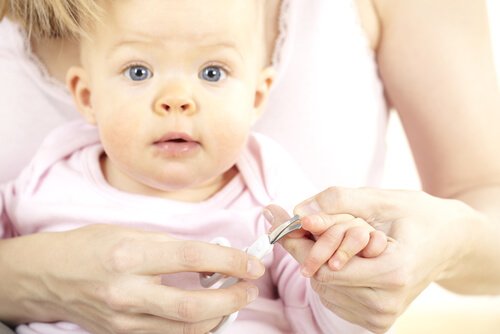 Vrouw knipt de nagels van je baby
