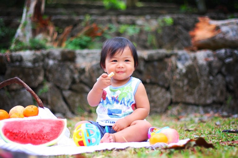Baby eet fruit tijdens het spelen