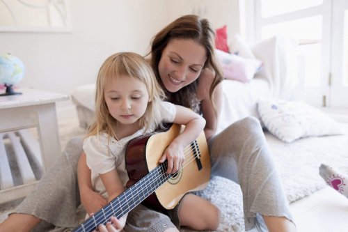 Een kind heeft talent voor gitaarspelen