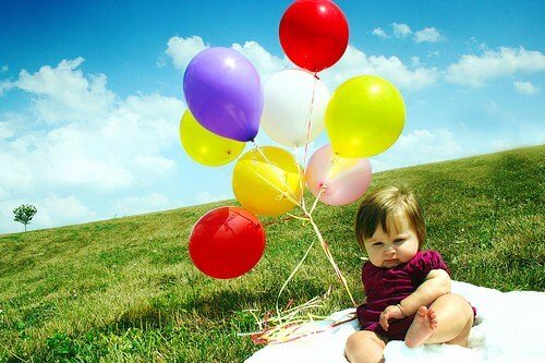 Baby met kleurrijke ballonnen