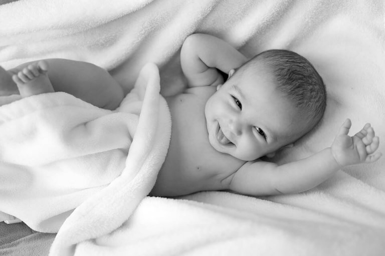 Lachende baby onder een deken