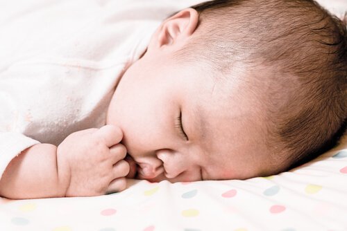 Slapende baby op een stippeltjes laken