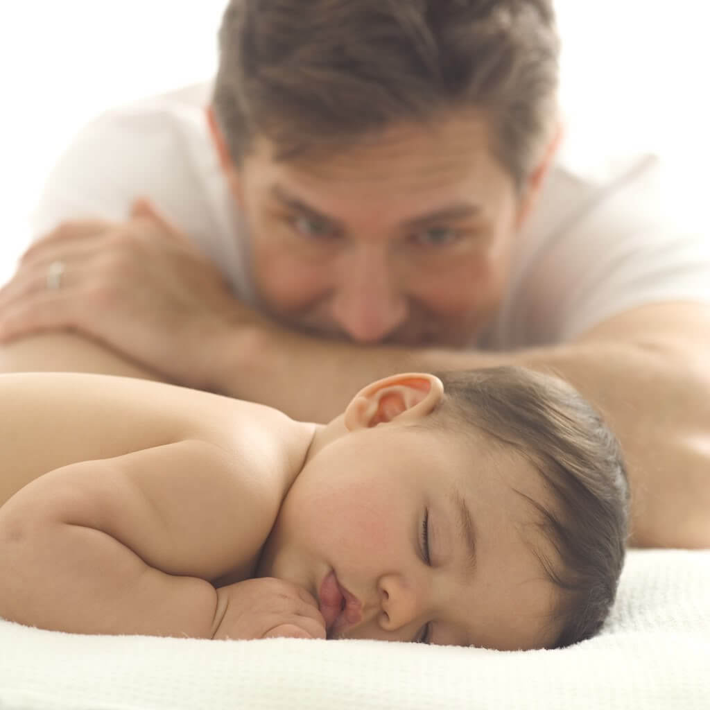 Vader kijkt naar slapende baby