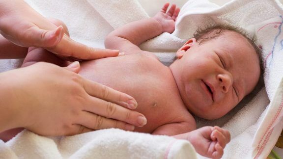 Moeder geeft baby massage om koliek te verlichten