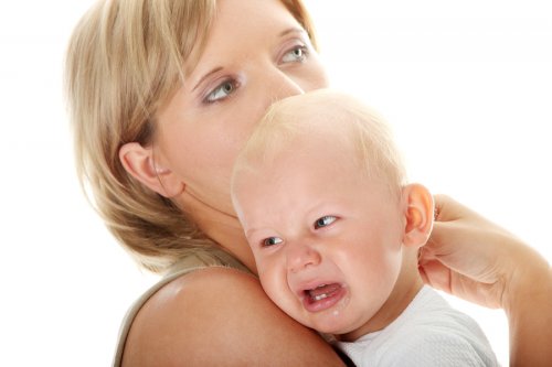 moeder draagt huilende baby