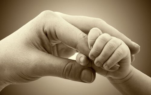Baby grijpt de vinger van mama