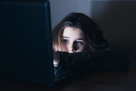 Meisje in het donker achter de pc