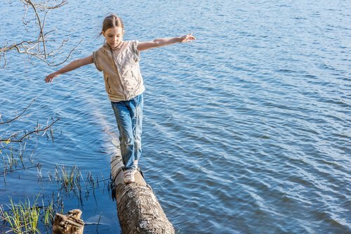 Meisje balanceert op een boomstam
