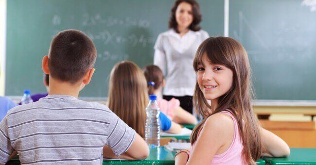 Meisje zit lachend in de klas