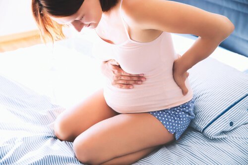 Zwangere vrouw met pijnlijke rug en buik