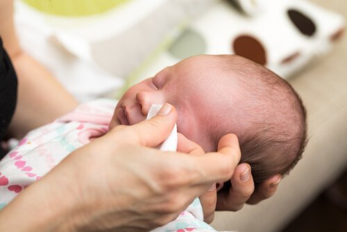 Moeder maakt de ogen van een baby schoon