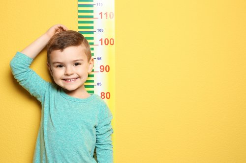 Jongen bij een meetlint op een muur