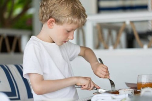 Een jongen snijdt zijn eten
