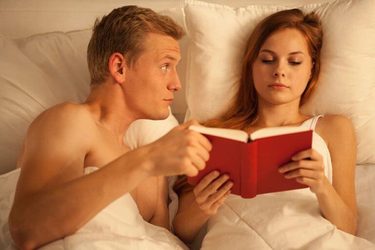 Man vraagt aandacht en vrouw leest verder in haar boek