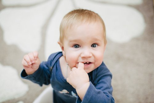Een baby met een vinger in zijn mond