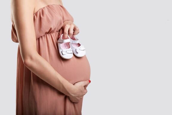 Zwangere vrouw met een paar babyschoentjes