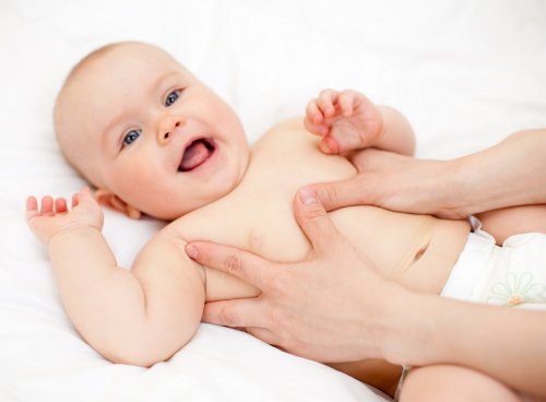 Lichaam van een baby wordt gemasseert
