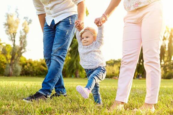 Ouders met een baby die leert lopen