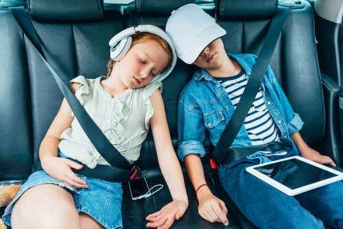 Twee kinderen slapen in de auto
