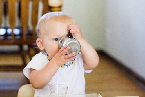 Een baby drinkt uit een beker