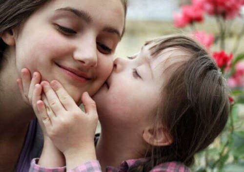 Een meisje geeft haar zus een kus