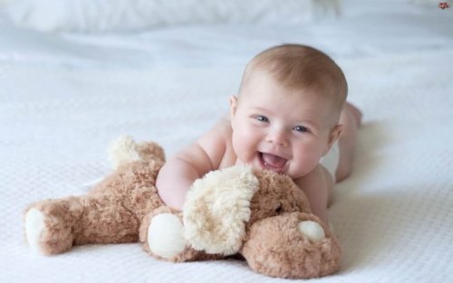 Een baby met een van zijn doopcadeau's