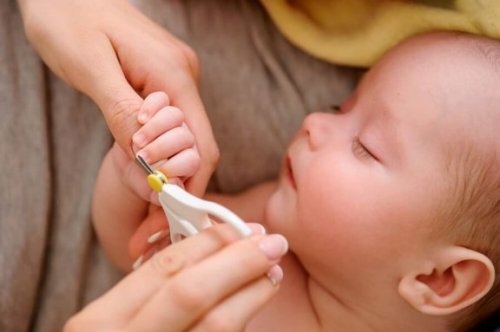 Moeder knipt de nagels van een slapende baby