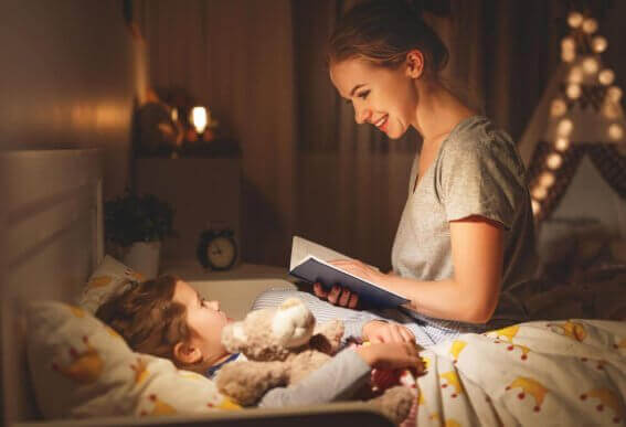 Moeder leest kindje in bed voor