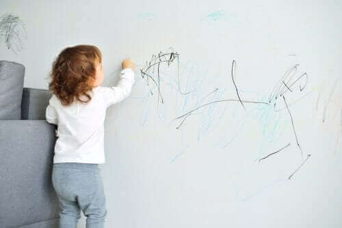 Kind maakt tekening op de muur