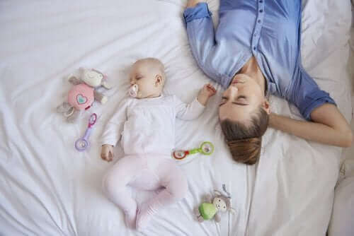 Moeder en baby slapen op bed